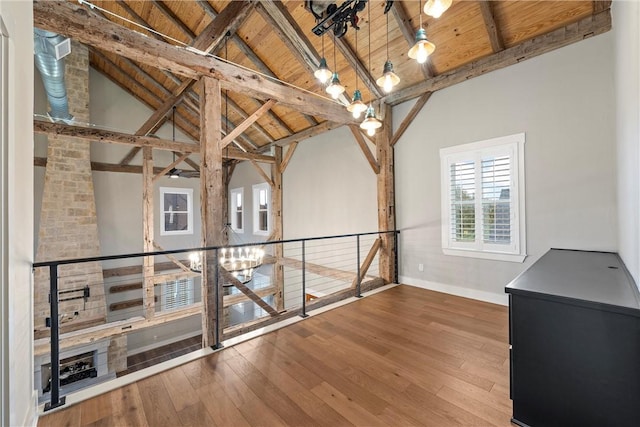 hallway with vaulted ceiling with beams, wood-type flooring, and wood ceiling