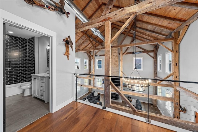 staircase with wooden ceiling, hardwood / wood-style floors, vaulted ceiling with beams, and an inviting chandelier