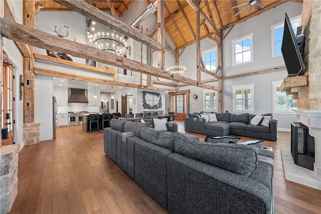 living room with high vaulted ceiling, wood ceiling, plenty of natural light, and a stone fireplace