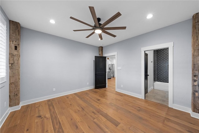 unfurnished bedroom featuring light wood-type flooring, ceiling fan, and connected bathroom