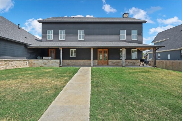 view of front of property with a patio area, a front yard, and french doors