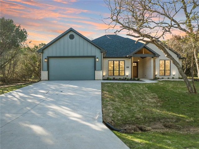 view of front of home with a yard and a garage