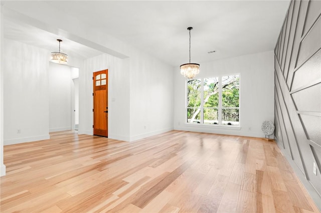 interior space with light hardwood / wood-style flooring and an inviting chandelier