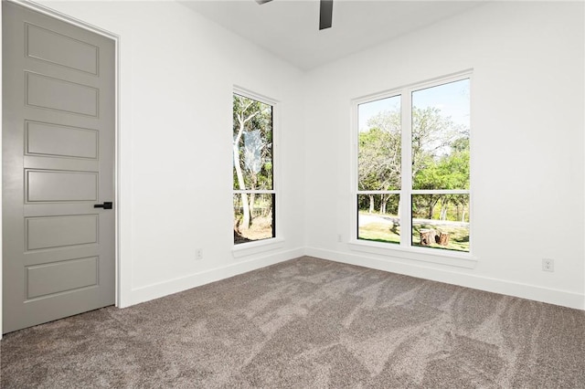 carpeted spare room featuring ceiling fan