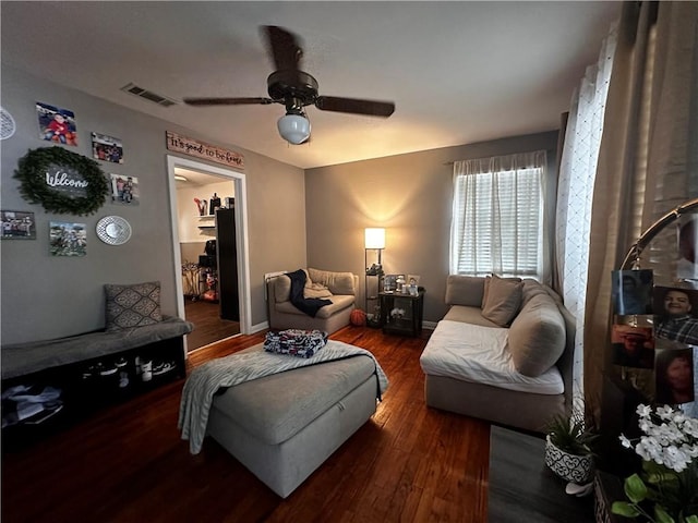 living room featuring ceiling fan and dark hardwood / wood-style flooring