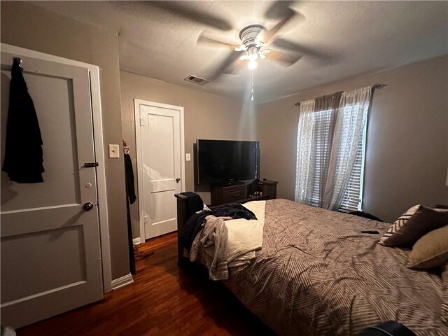 bedroom with ceiling fan and dark hardwood / wood-style flooring