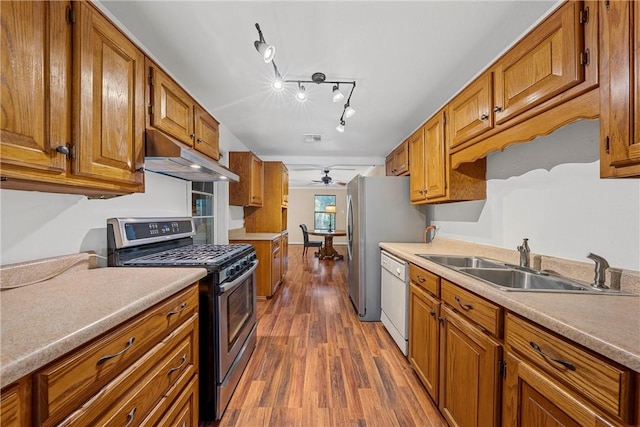 kitchen with dishwasher, dark wood-type flooring, stainless steel range with gas cooktop, sink, and ceiling fan