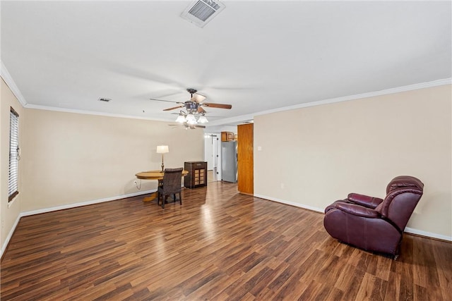 living area with ceiling fan, dark hardwood / wood-style floors, and ornamental molding