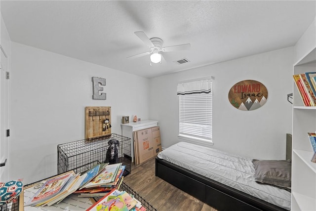 bedroom with ceiling fan, hardwood / wood-style floors, and a textured ceiling