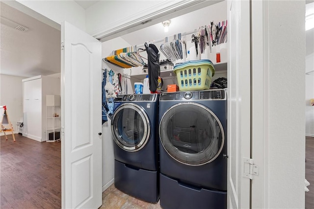 laundry area featuring separate washer and dryer and hardwood / wood-style flooring