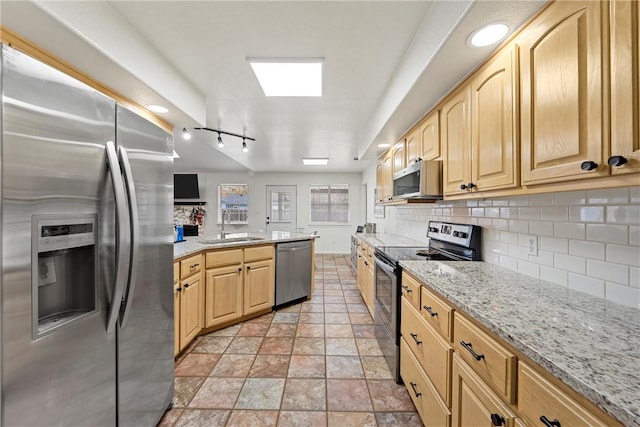 kitchen with tasteful backsplash, sink, light brown cabinets, and appliances with stainless steel finishes