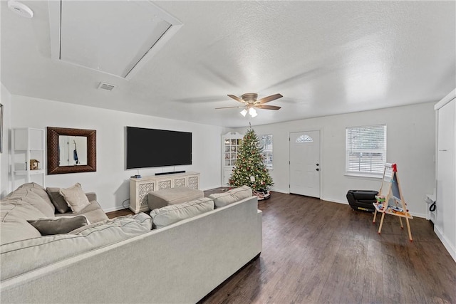 living room featuring ceiling fan, dark hardwood / wood-style flooring, and a textured ceiling