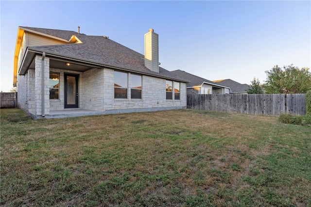 back of property with a patio area and a lawn