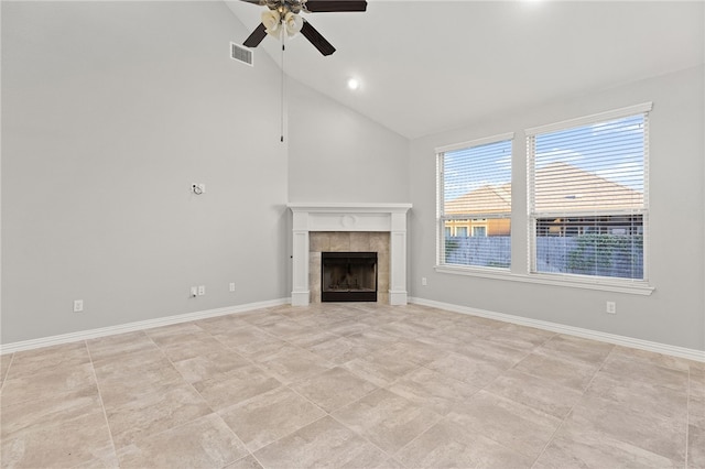 unfurnished living room with a tile fireplace, ceiling fan, and high vaulted ceiling