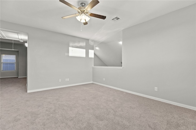 empty room featuring carpet flooring, ceiling fan, and vaulted ceiling