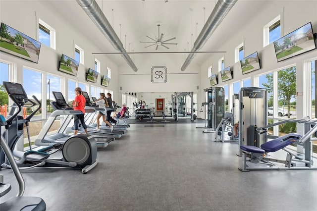 gym featuring ceiling fan and a towering ceiling