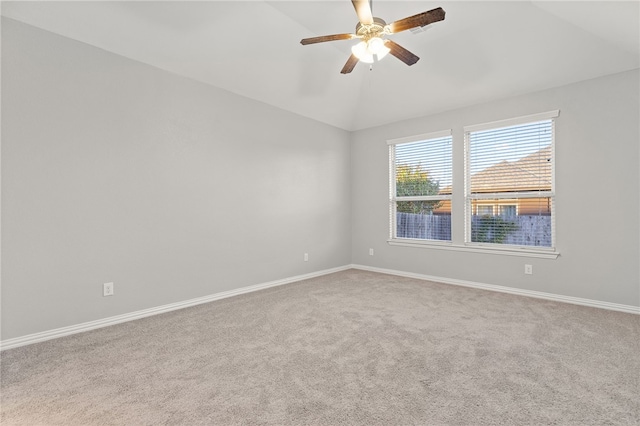 spare room featuring carpet, ceiling fan, and vaulted ceiling