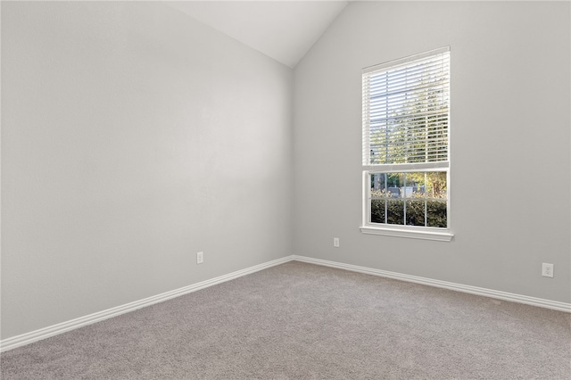 unfurnished room with carpet floors and vaulted ceiling