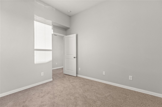 spare room featuring light colored carpet