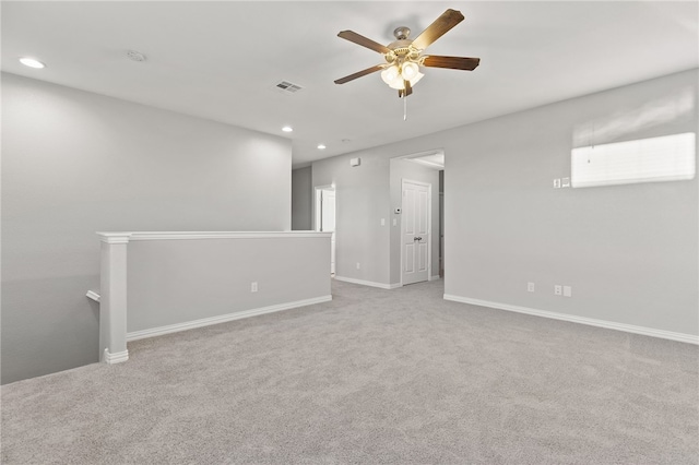 carpeted spare room featuring ceiling fan