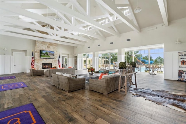 living room with beam ceiling, a fireplace, high vaulted ceiling, and wood-type flooring