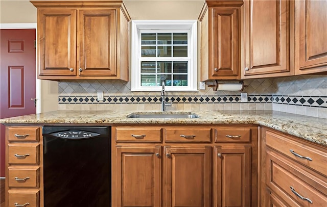 kitchen featuring light stone countertops, black dishwasher, tasteful backsplash, and sink