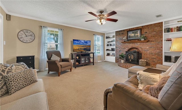 living room with a textured ceiling, built in features, a wood stove, and carpet floors