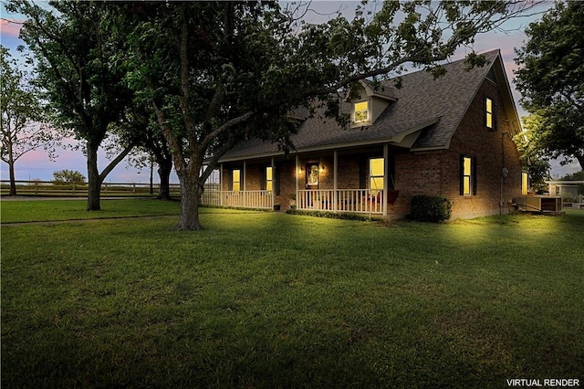 view of front of property with a porch and a yard