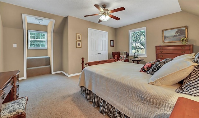 carpeted bedroom with multiple windows, ceiling fan, and lofted ceiling