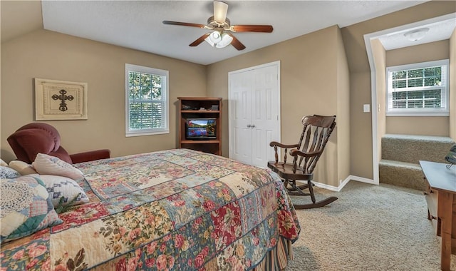 carpeted bedroom featuring multiple windows, ceiling fan, a closet, and lofted ceiling