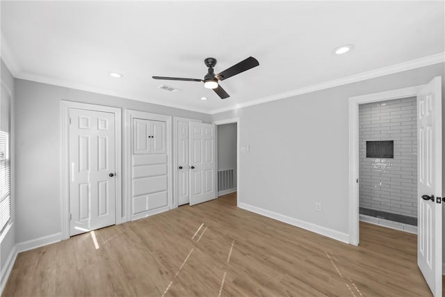 unfurnished bedroom with ornamental molding, ceiling fan, light hardwood / wood-style flooring, connected bathroom, and multiple closets