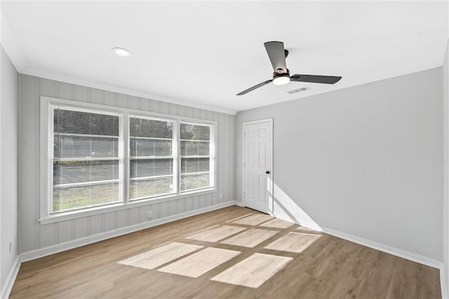 empty room with ceiling fan, plenty of natural light, and light hardwood / wood-style floors