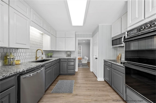 kitchen featuring white cabinets, appliances with stainless steel finishes, and gray cabinetry