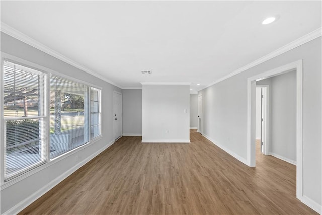 empty room with wood-type flooring and ornamental molding