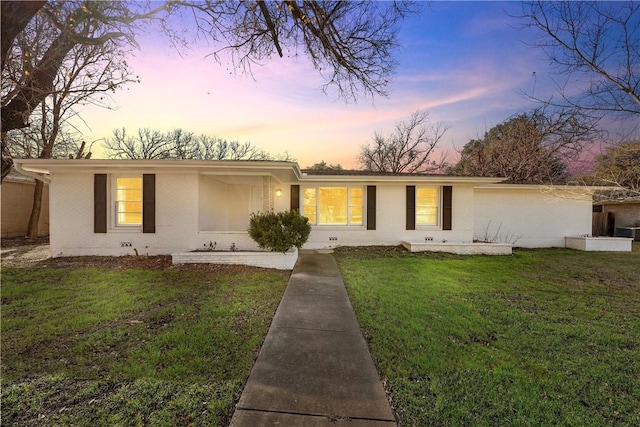 ranch-style home with a yard