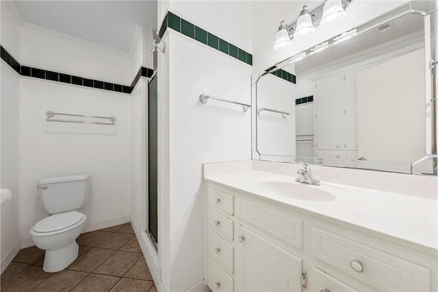 bathroom with tile patterned flooring, vanity, toilet, and walk in shower