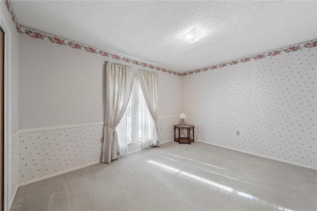 carpeted spare room featuring a textured ceiling