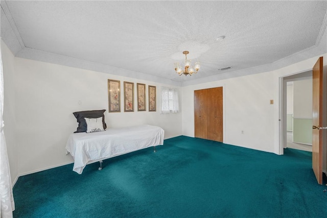 carpeted bedroom featuring a textured ceiling, an inviting chandelier, and a closet