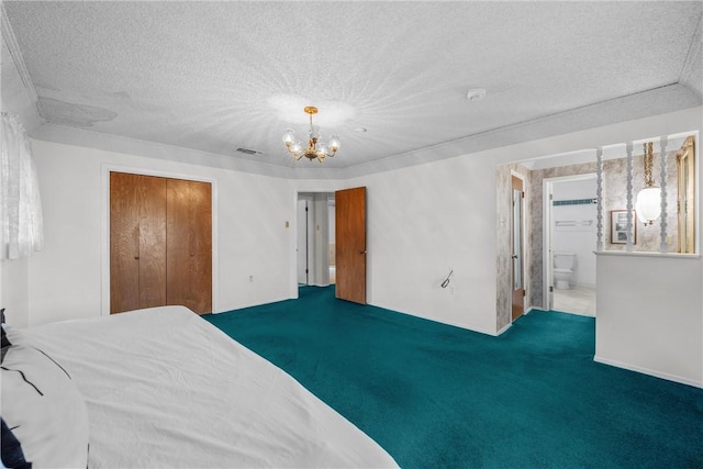 bedroom with ensuite bathroom, a closet, carpet, and a textured ceiling