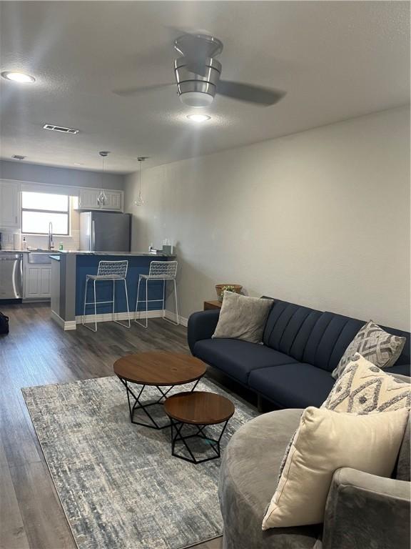 living room with ceiling fan, dark hardwood / wood-style flooring, and sink