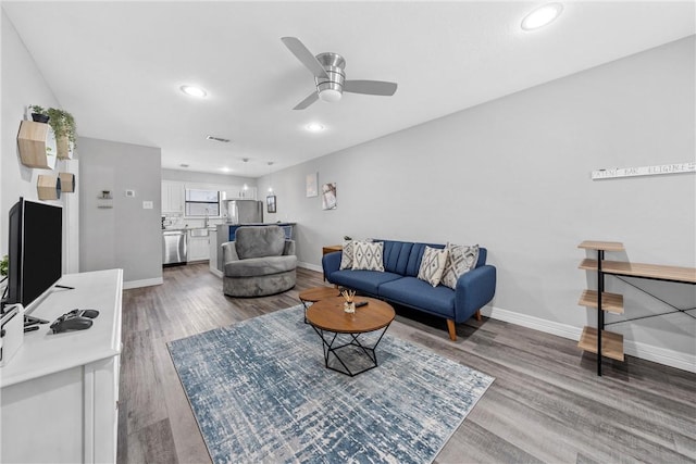 living room featuring hardwood / wood-style flooring and ceiling fan