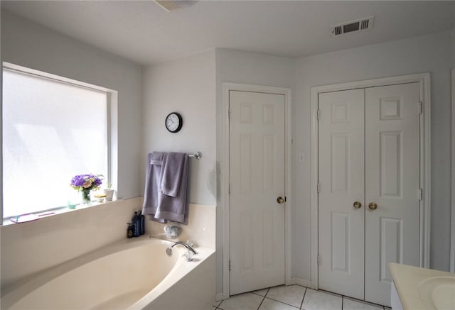 bathroom featuring a bathing tub, tile patterned floors, and vanity