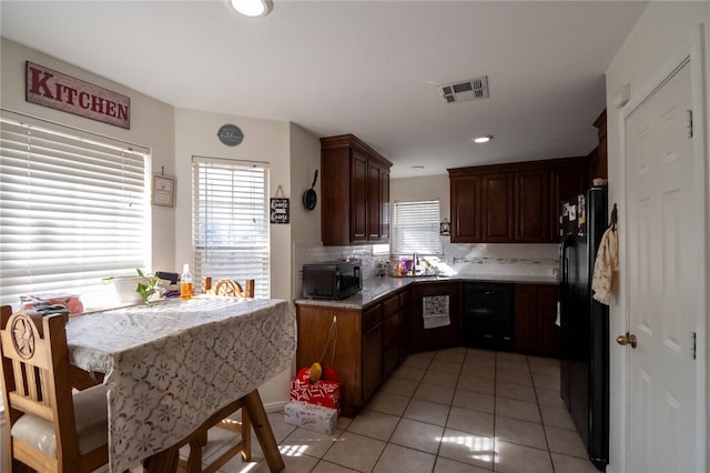 kitchen with light tile patterned flooring, decorative backsplash, and black appliances