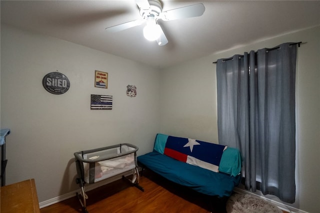 living area with ceiling fan and dark hardwood / wood-style flooring