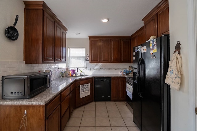 kitchen with sink, light stone counters, light tile patterned floors, backsplash, and black appliances