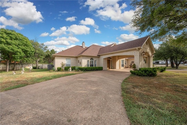 view of front of house with a front lawn, a carport, and central air condition unit