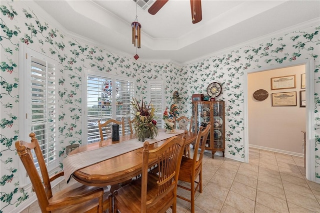 tiled dining area featuring a raised ceiling, ceiling fan, and ornamental molding