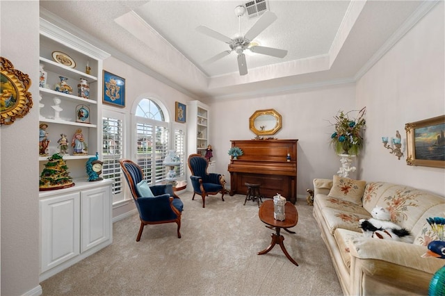 sitting room with a tray ceiling, crown molding, ceiling fan, and light carpet