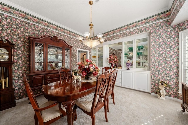 dining space featuring crown molding, light carpet, and a chandelier