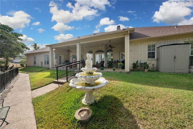 back of property with a lawn and ceiling fan